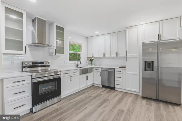 a kitchen with a white cabinets a sink and wooden floor