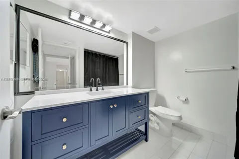a bathroom with a granite countertop sink a toilet and a mirror