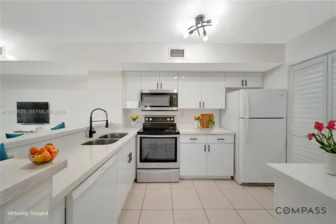 a kitchen with stainless steel appliances granite countertop a refrigerator sink stove and refrigerator