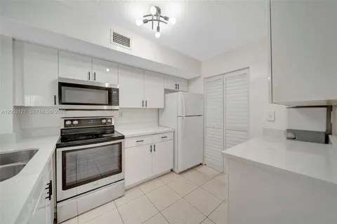 a kitchen with granite countertop a stove sink and refrigerator
