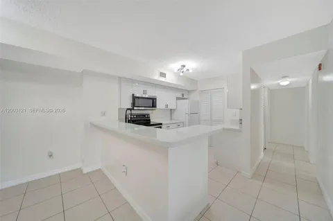 a view of kitchen with sink and refrigerator