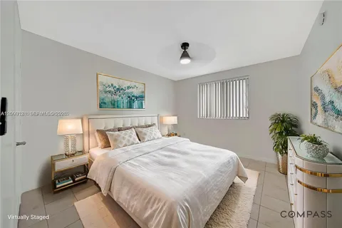 a bedroom with bed and a potted plant