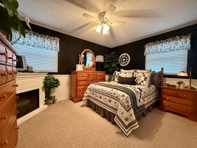 a spacious bedroom with a bed and a ceiling fan