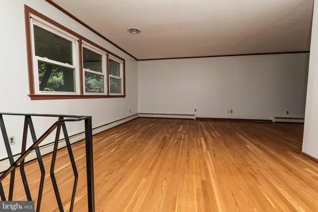 a view of a livingroom with wooden floor and window