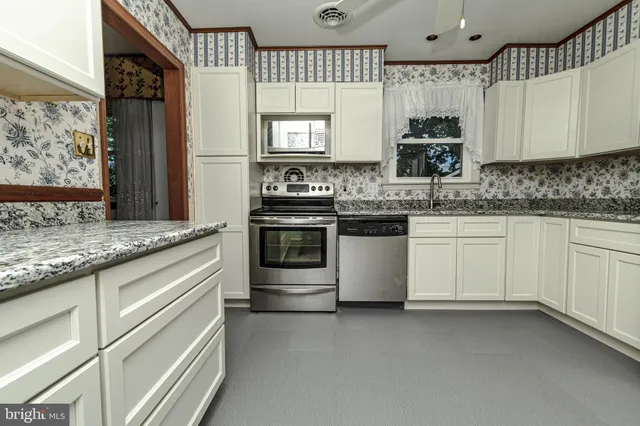 a kitchen with stainless steel appliances granite countertop a refrigerator stove and sink