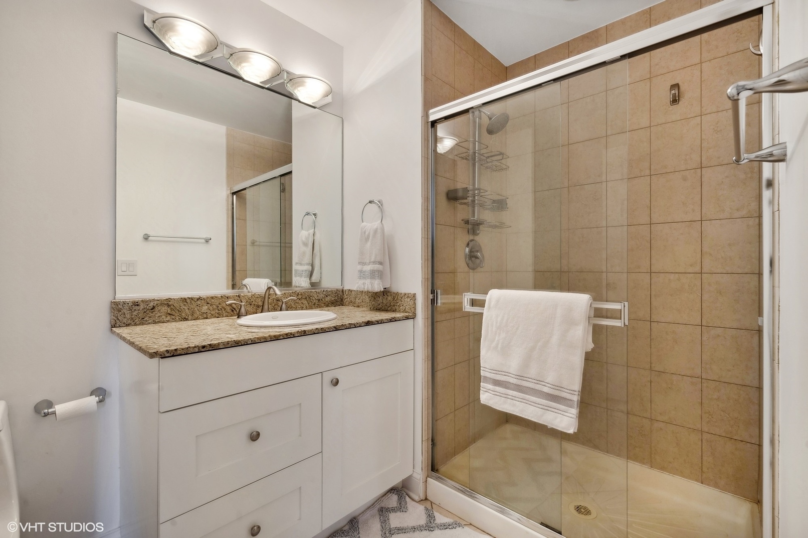 910 West Madison Street, Unit 608 Chicago, IL 60607 - Photo 11 of 15 a bathroom with a granite countertop sink a toilet a mirror and shower