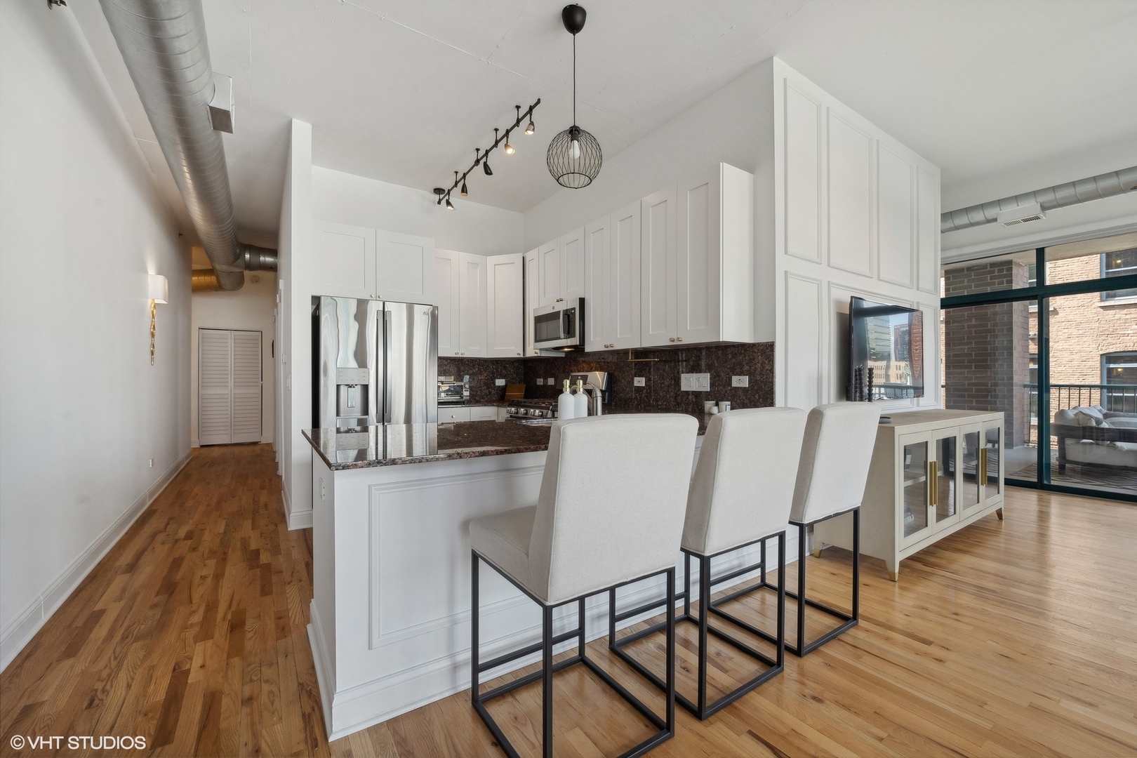 910 West Madison Street, Unit 608 Chicago, IL 60607 - Photo 8 of 15 a kitchen with stainless steel appliances granite countertop a stove a refrigerator a kitchen island a dining table and chairs with wooden floor