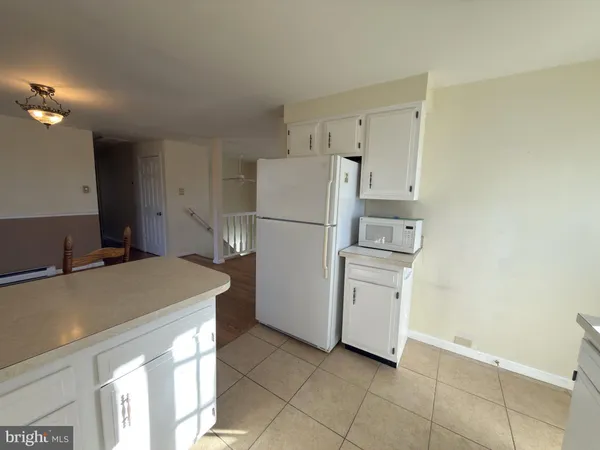 a kitchen with a refrigerator and a stove top oven