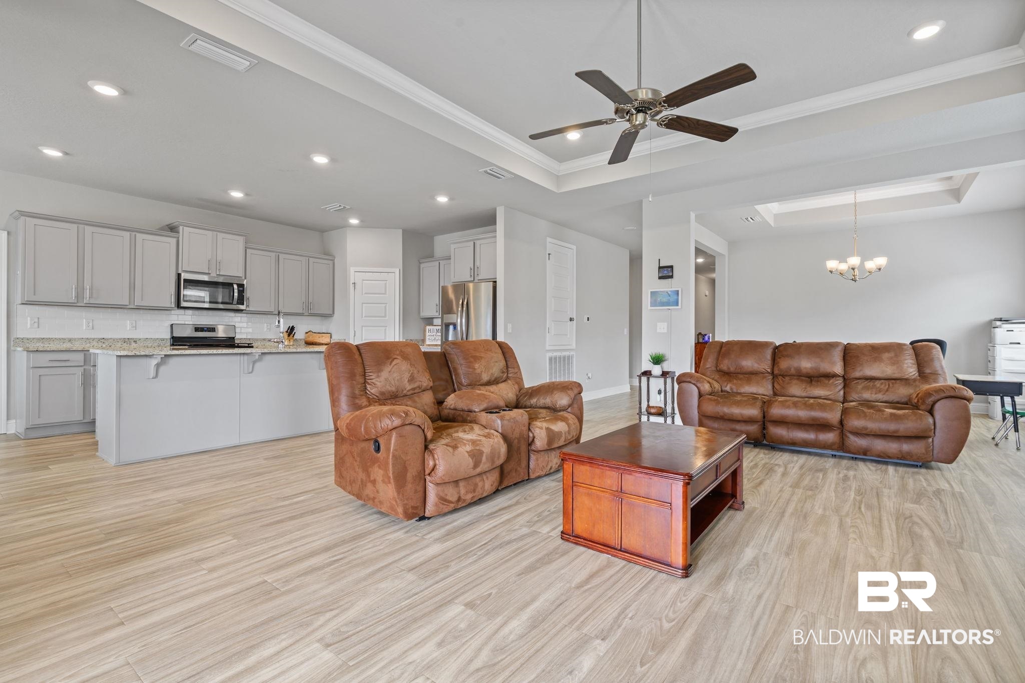 2183 Meadowview Loop Semmes, AL 36575 - Photo 34 of 58 Living area with a ceiling fan, light wood-type flooring, crown molding, a raised ceiling, and hanging lights