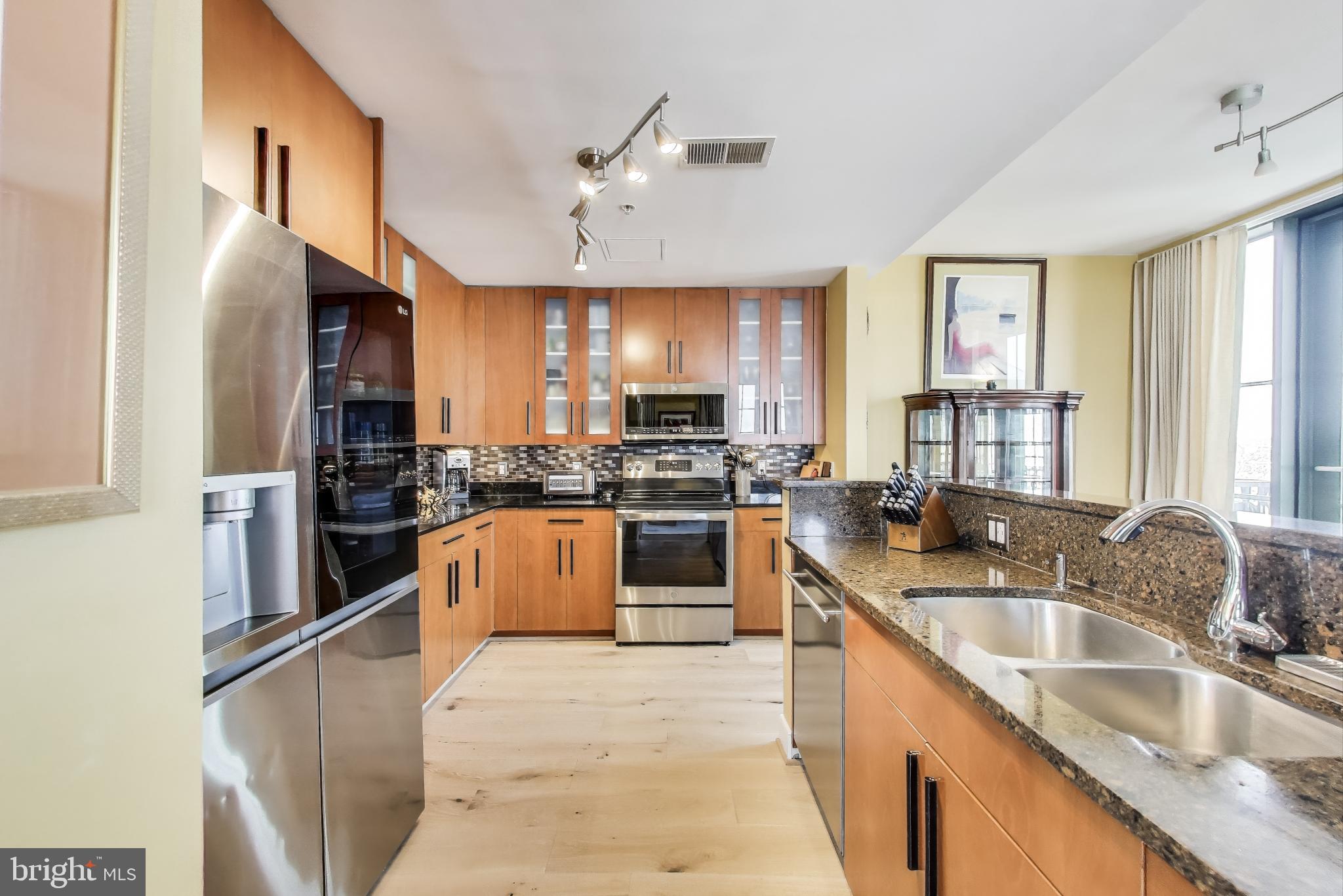 910 M Street Northwest, Unit 1022 Washington, DC 20001 - Photo 14 of 64 a kitchen with granite countertop a stove sink and refrigerator