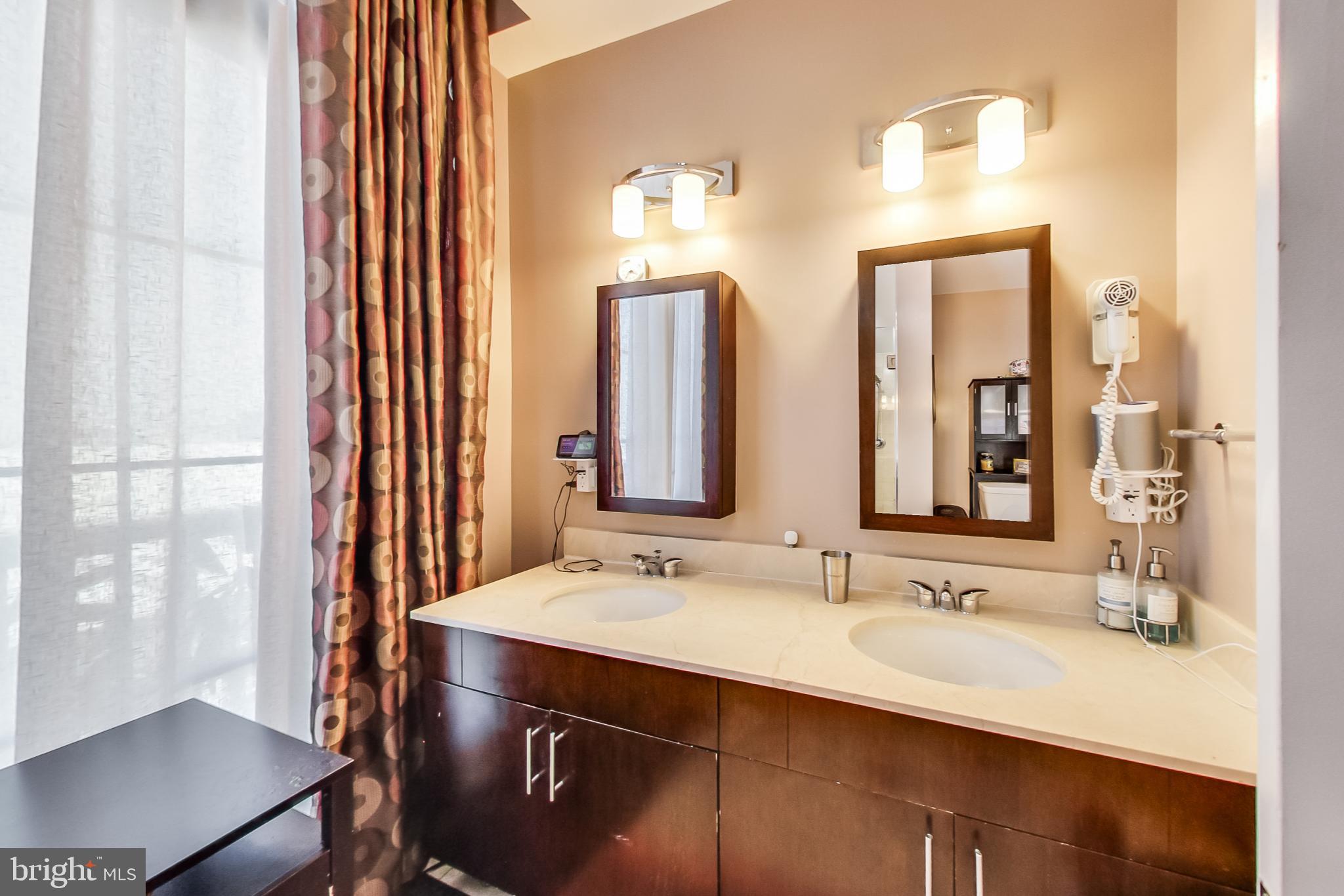 910 M Street Northwest, Unit 1022 Washington, DC 20001 - Photo 27 of 64 a bathroom with a double vanity sink and a mirror