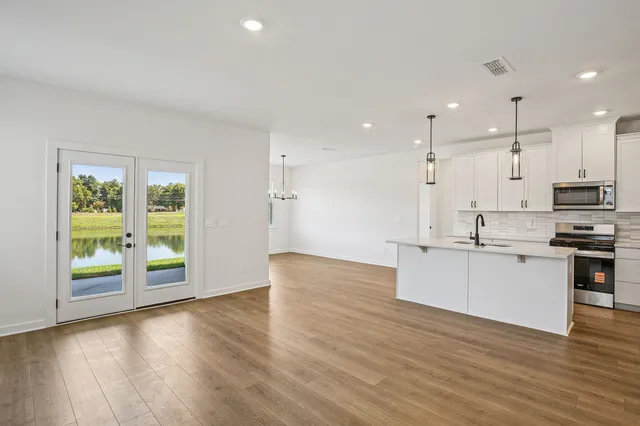 a view of a kitchen with a sink and wooden floor