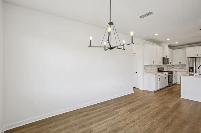 a kitchen with stainless steel appliances granite countertop a stove top oven a sink and a refrigerator