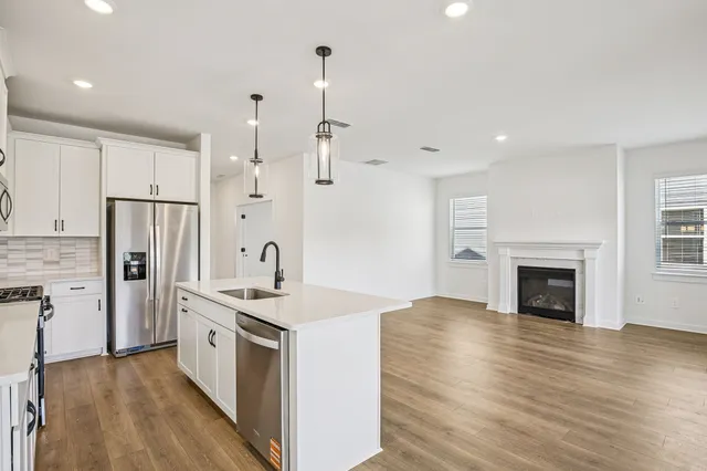 a view of large kitchen with wooden floor and windows