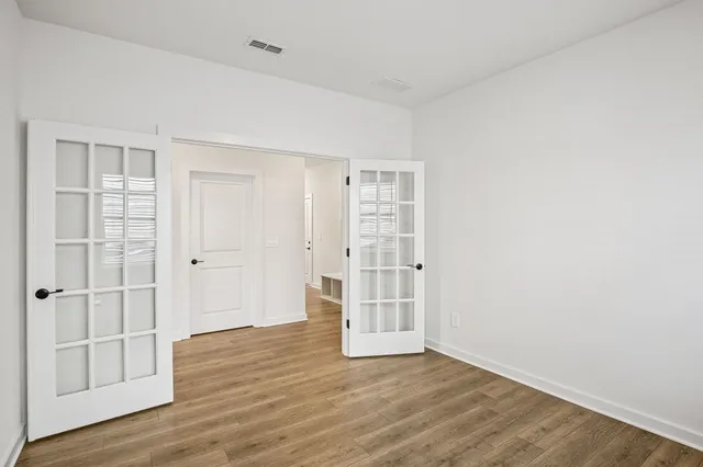 a view of a room with a window and wooden floor
