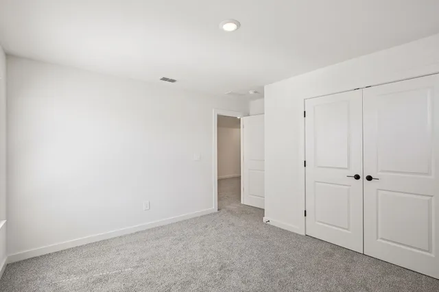 a view of a yard in front of a house with plants and large tree