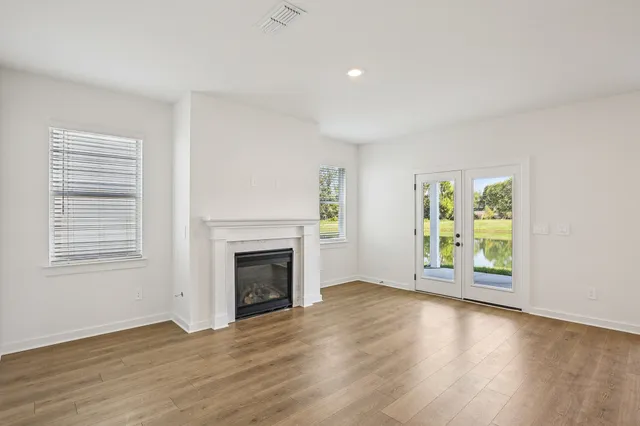 a view of empty room with wooden floor and fireplace