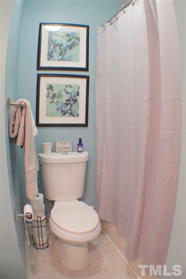 4436 Archibald Way Raleigh, NC 27616 - Photo 15 of 25 a bathroom with a toilet and a shower curtain