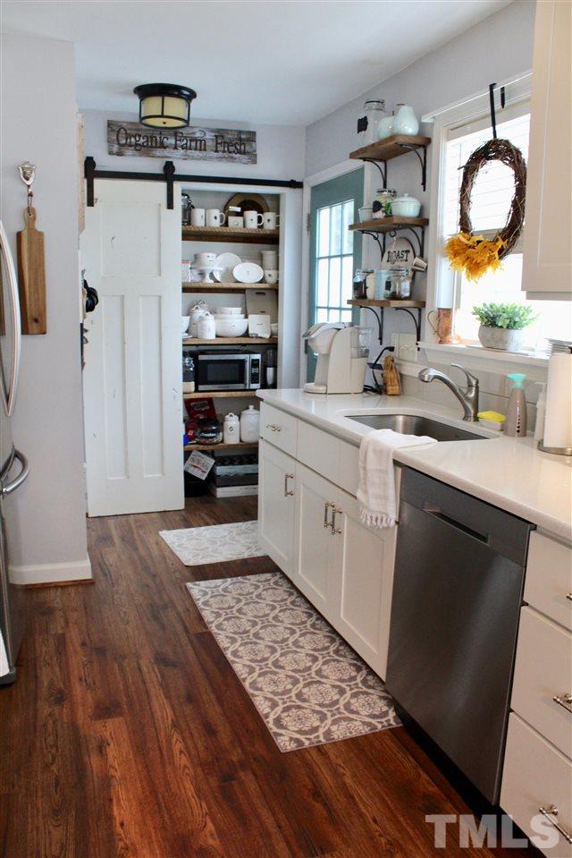 4436 Archibald Way Raleigh, NC 27616 - Photo 10 of 25 a kitchen with stainless steel appliances granite countertop a sink dishwasher stove and cabinets with wooden floor