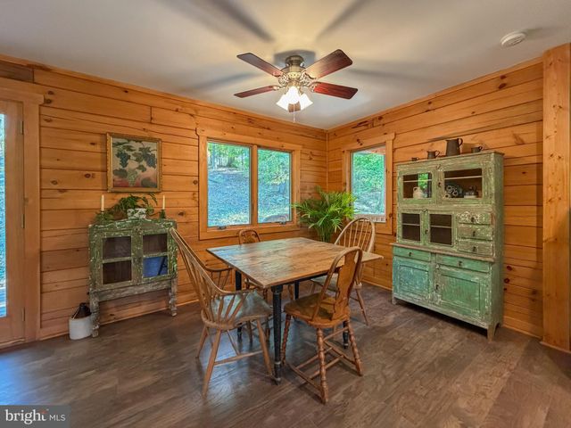 a dining room with a wooden table and chairs