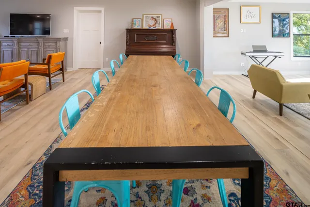 a room with wooden floor pool table and couch