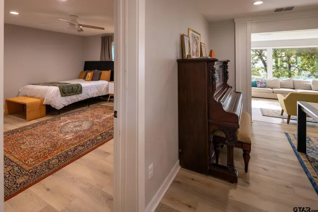 a view of a bedroom with wooden floor and windows