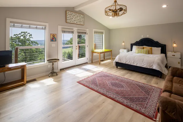 a bedroom with a bed a large window and walk in closet