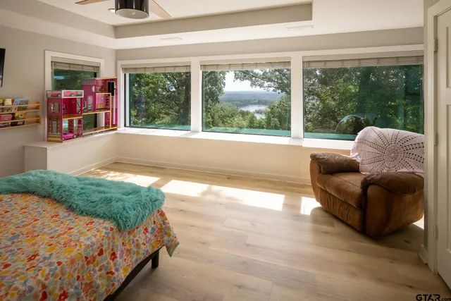 a spacious bedroom with a bed and glass window