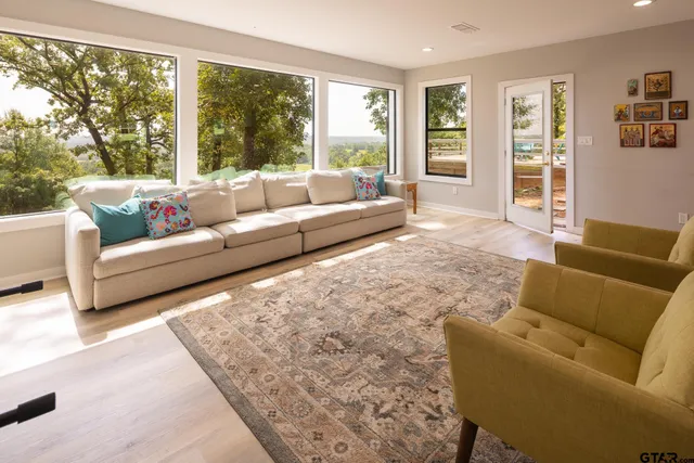 a living room with furniture and large windows