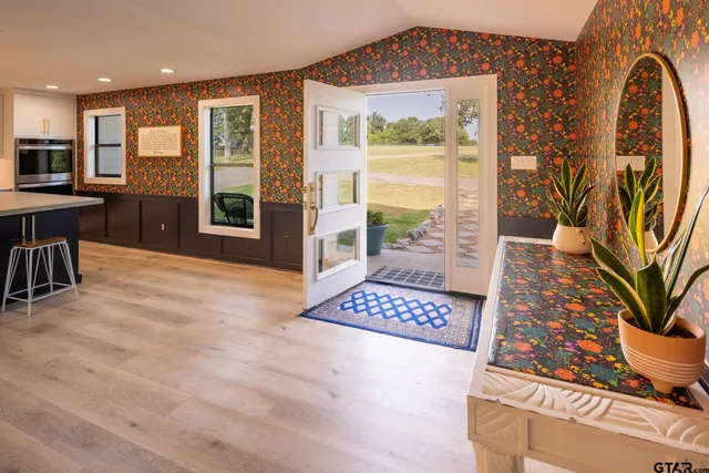 a view of an entryway with wooden floor and a rug