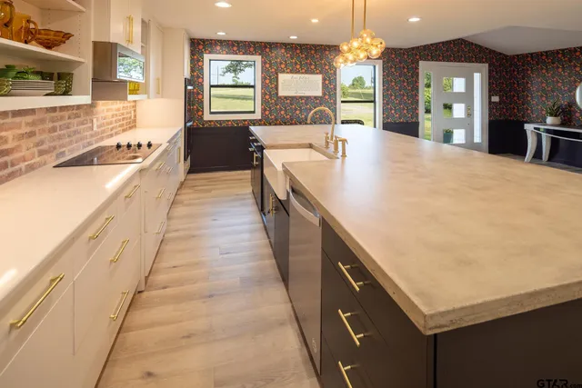 a large kitchen with kitchen island a sink counter space appliances and a large window