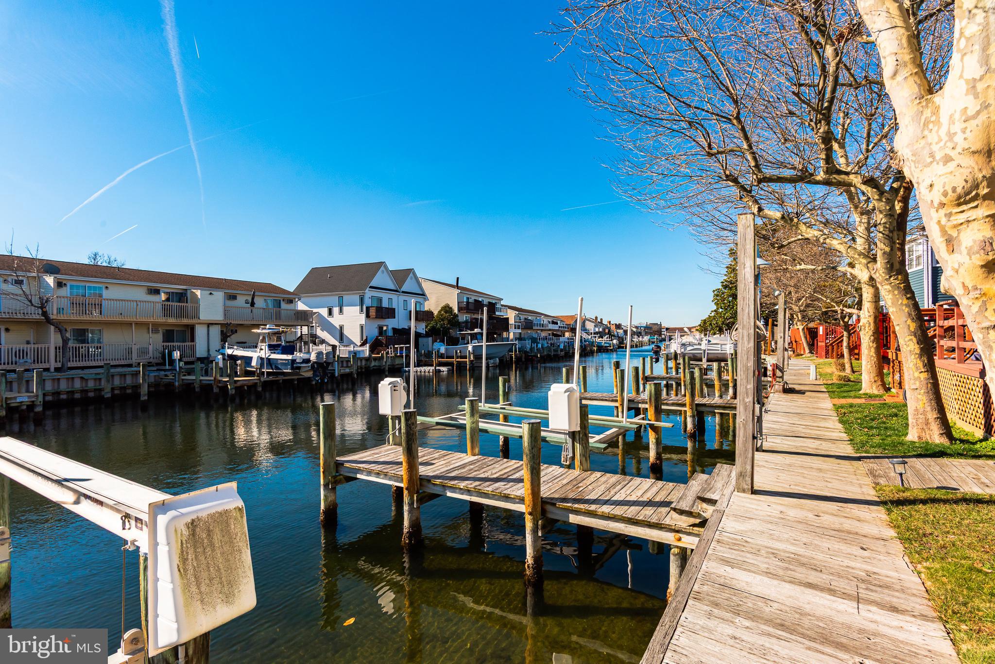 131 Newport Bay Drive, Unit 2 Ocean City, MD 21842 - Photo 14 of 61 a view of a lake with boats and trees in the background