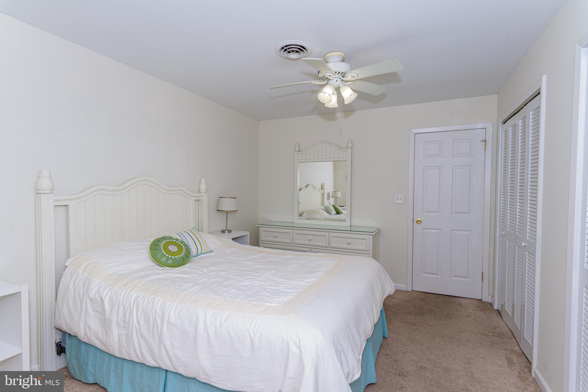 131 Newport Bay Drive, Unit 2 Ocean City, MD 21842 - Photo 27 of 61 a bedroom with a bed and a chandelier