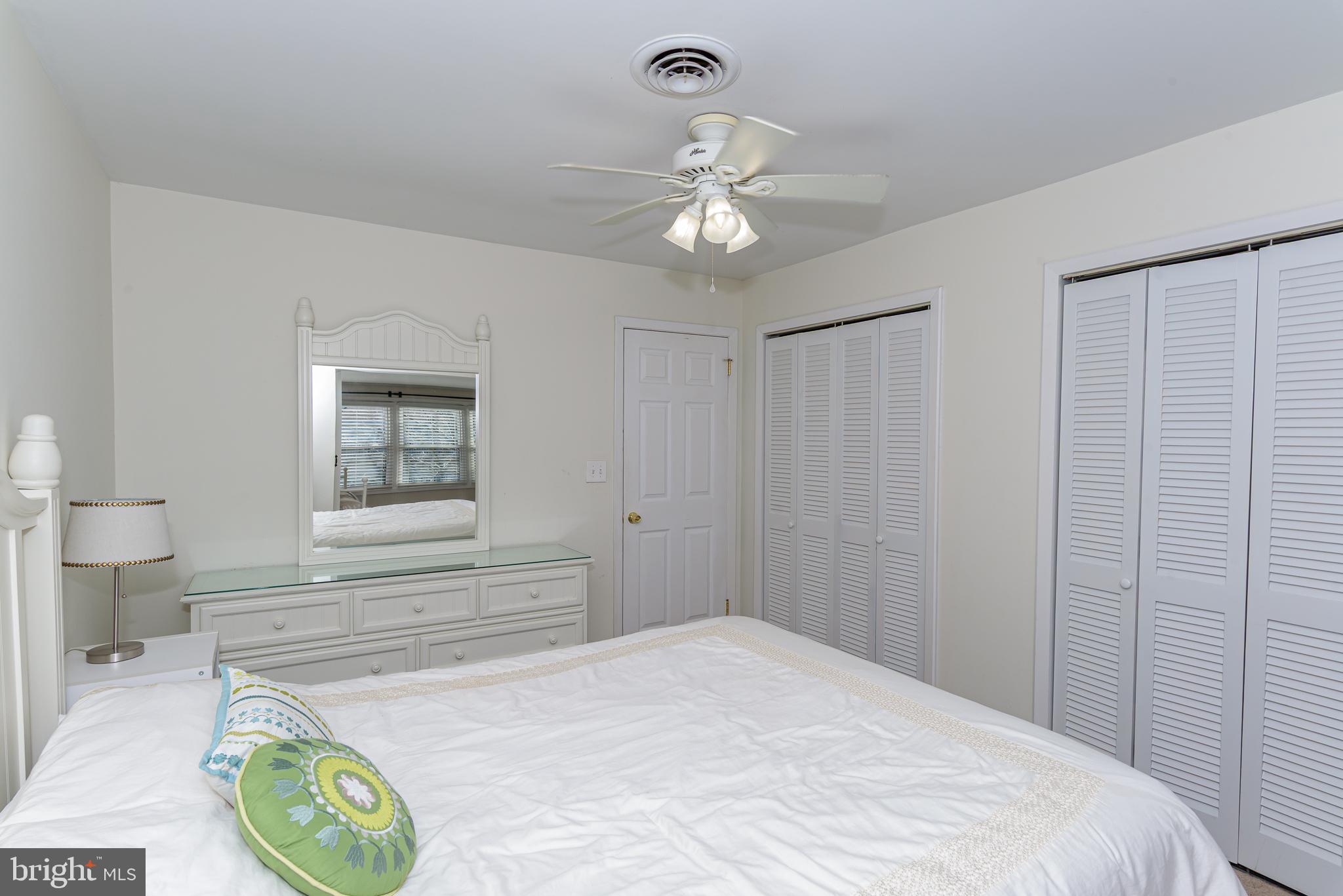 131 Newport Bay Drive, Unit 2 Ocean City, MD 21842 - Photo 29 of 61 a bedroom with a bed and a chandelier