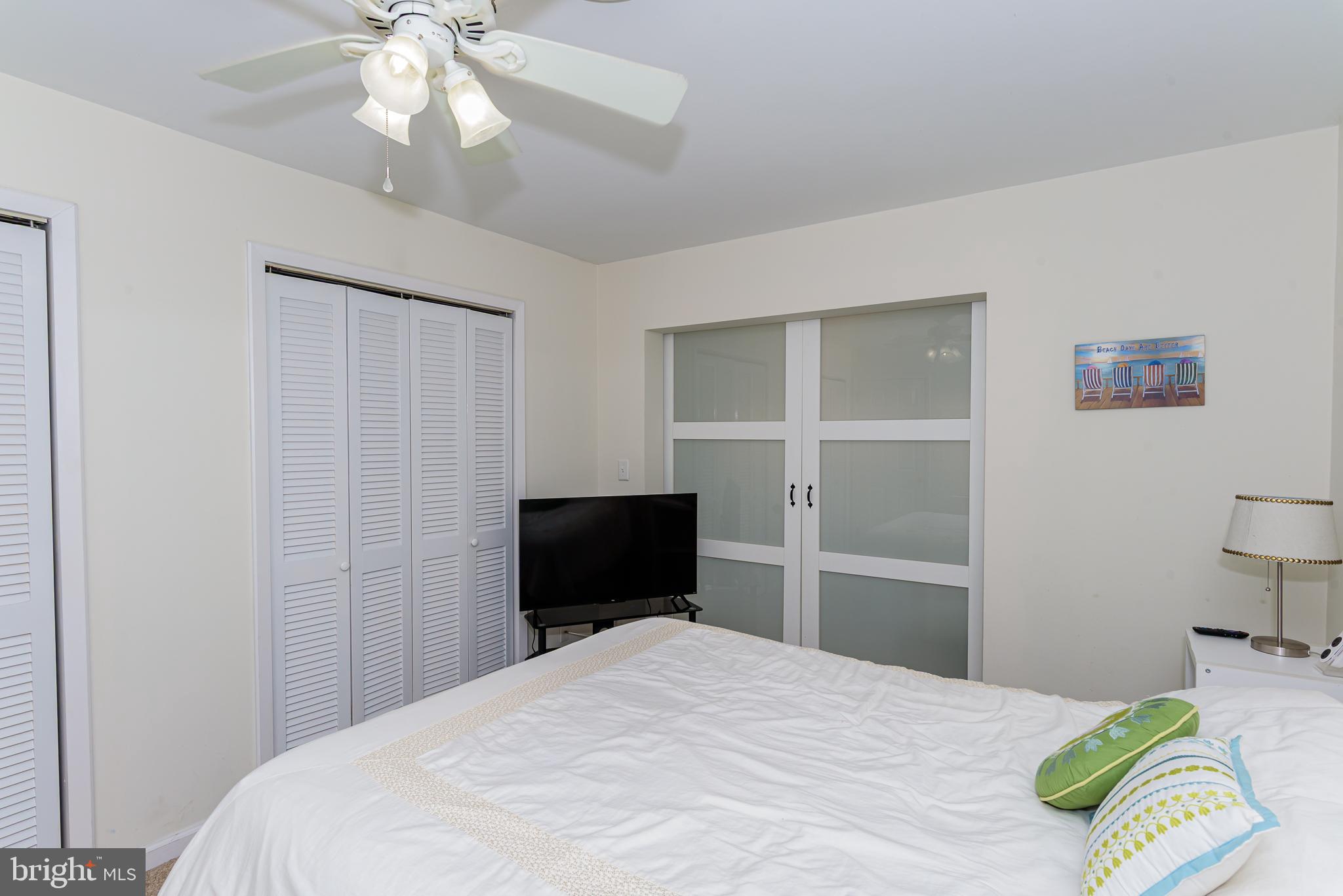 131 Newport Bay Drive, Unit 2 Ocean City, MD 21842 - Photo 31 of 61 a bedroom with a bed and a chandelier