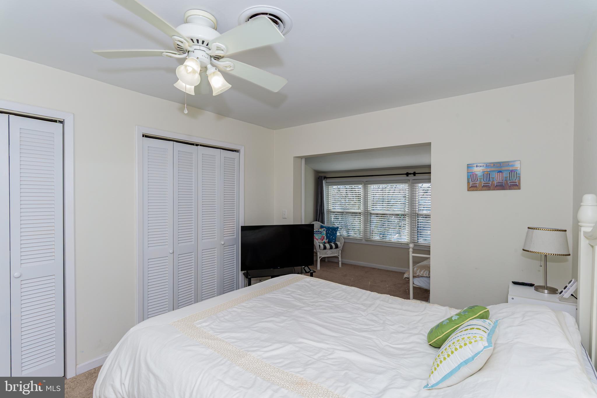 131 Newport Bay Drive, Unit 2 Ocean City, MD 21842 - Photo 32 of 61 a bedroom with a bed and a chandelier