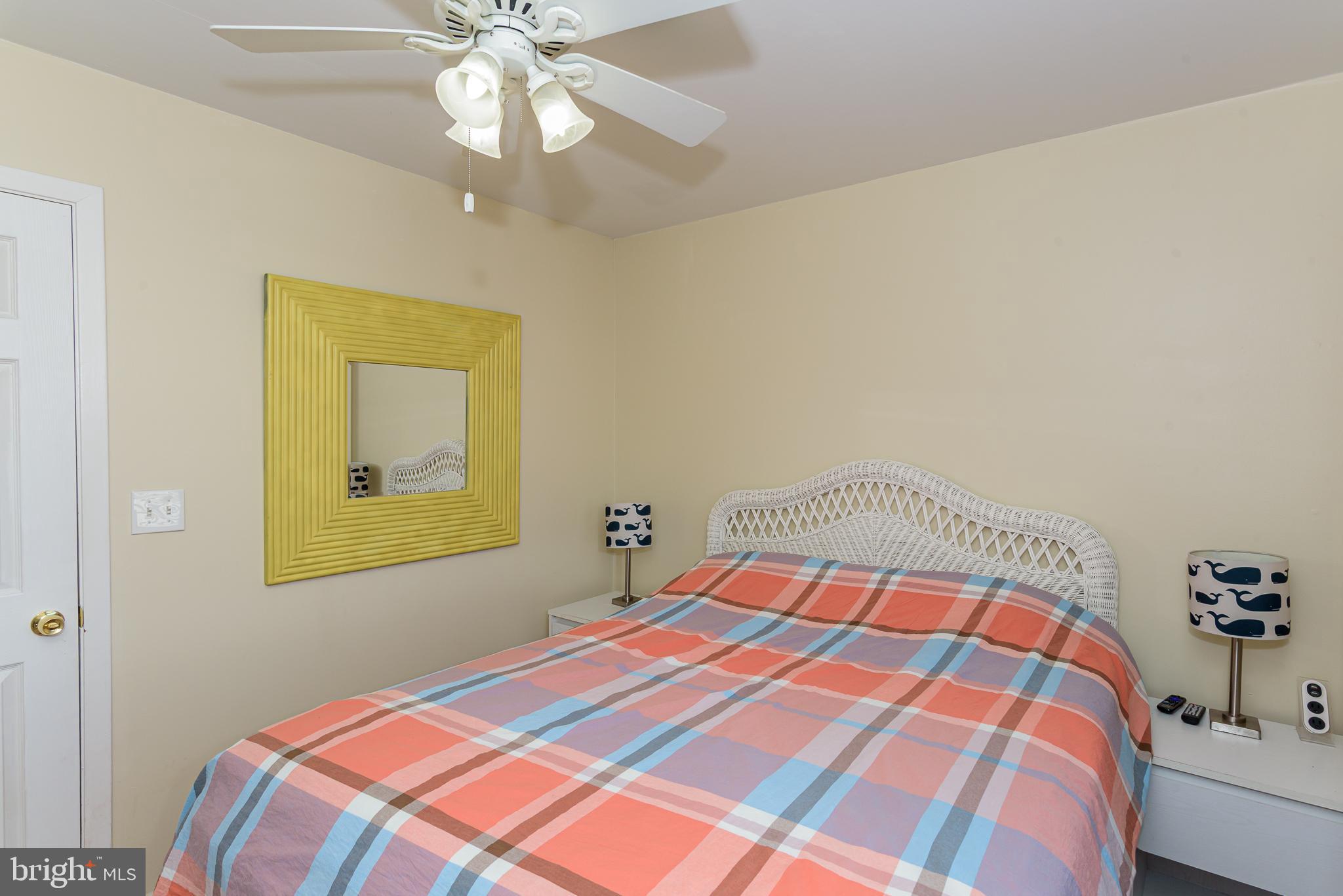 131 Newport Bay Drive, Unit 2 Ocean City, MD 21842 - Photo 36 of 61 a bedroom with a bed and a chandelier