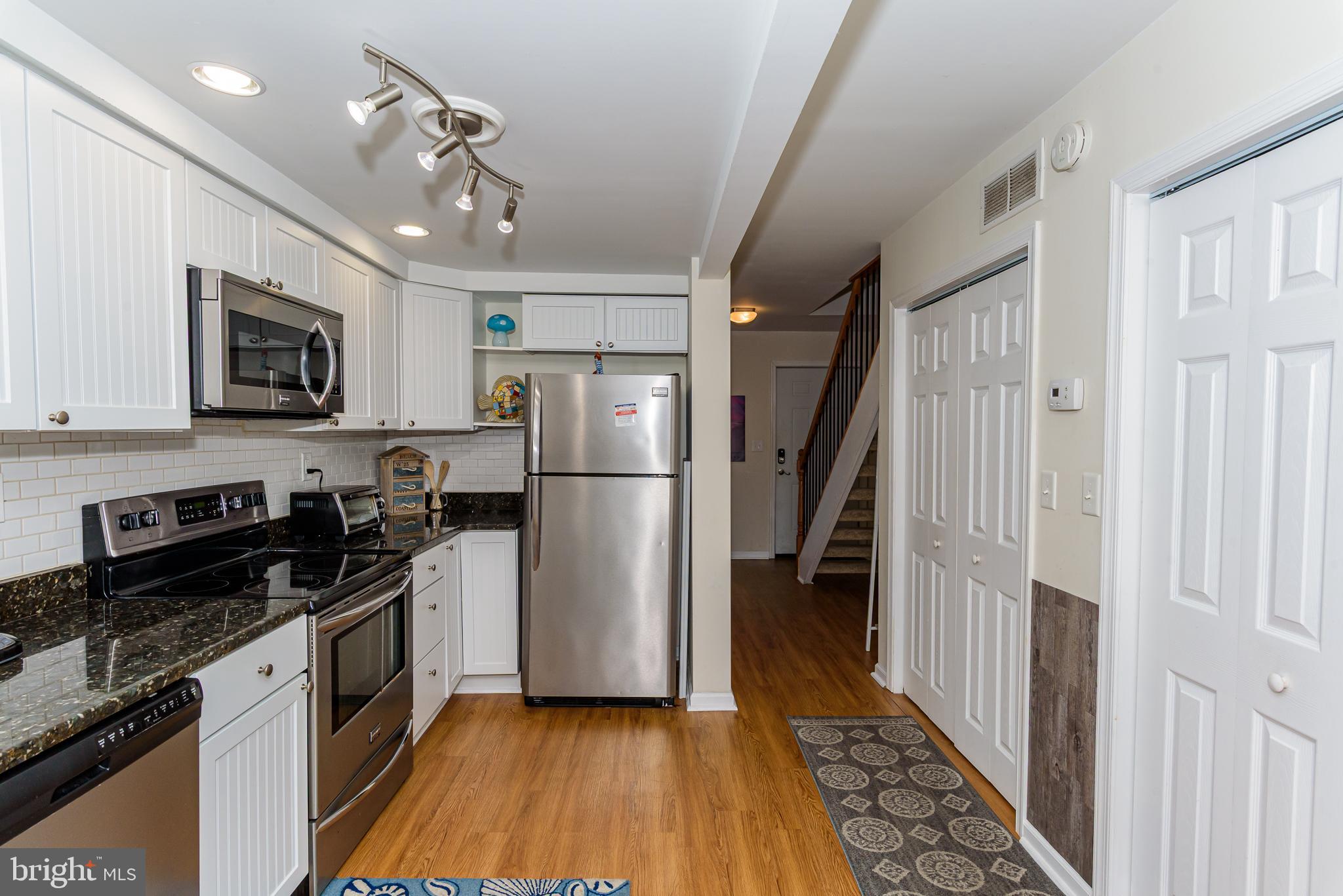 131 Newport Bay Drive, Unit 2 Ocean City, MD 21842 - Photo 46 of 61 a kitchen with granite countertop a refrigerator a stove top oven a sink and dishwasher