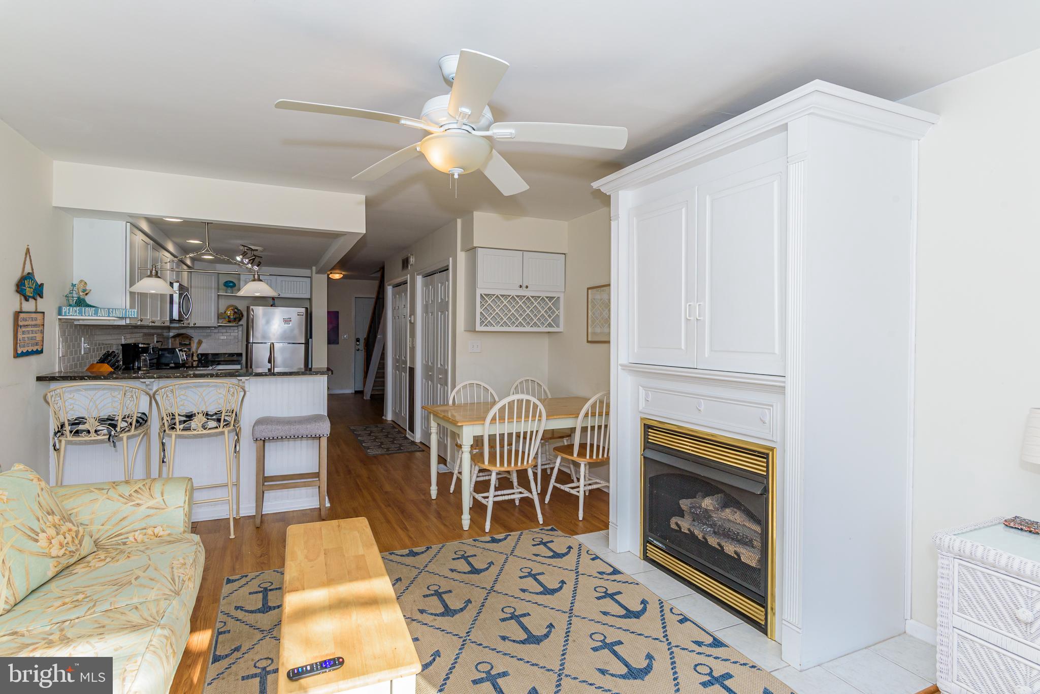 131 Newport Bay Drive, Unit 2 Ocean City, MD 21842 - Photo 59 of 61 a living room with furniture a fireplace and kitchen view