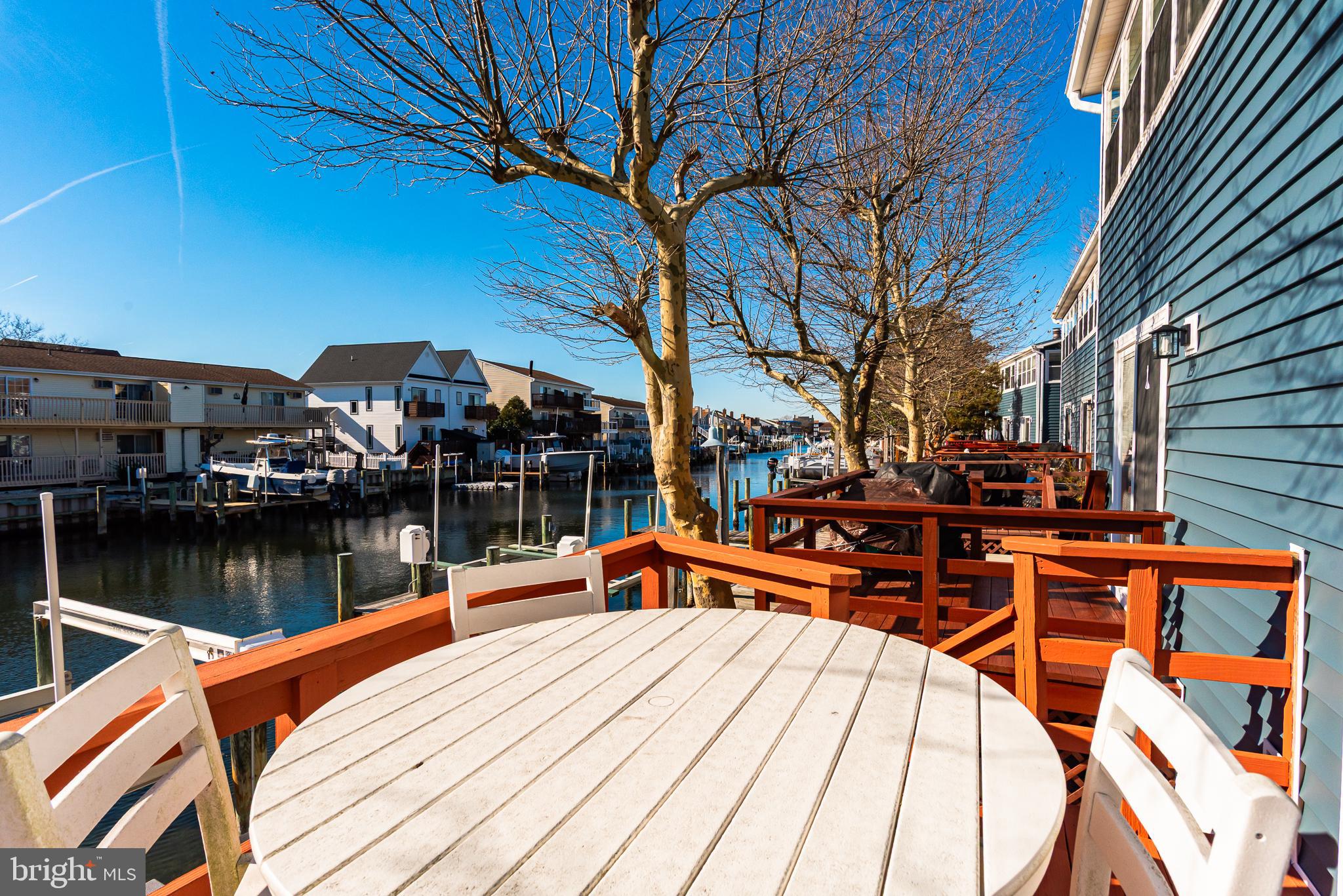131 Newport Bay Drive, Unit 2 Ocean City, MD 21842 - Photo 8 of 61 a wooden bench sitting on a pier next to a lake