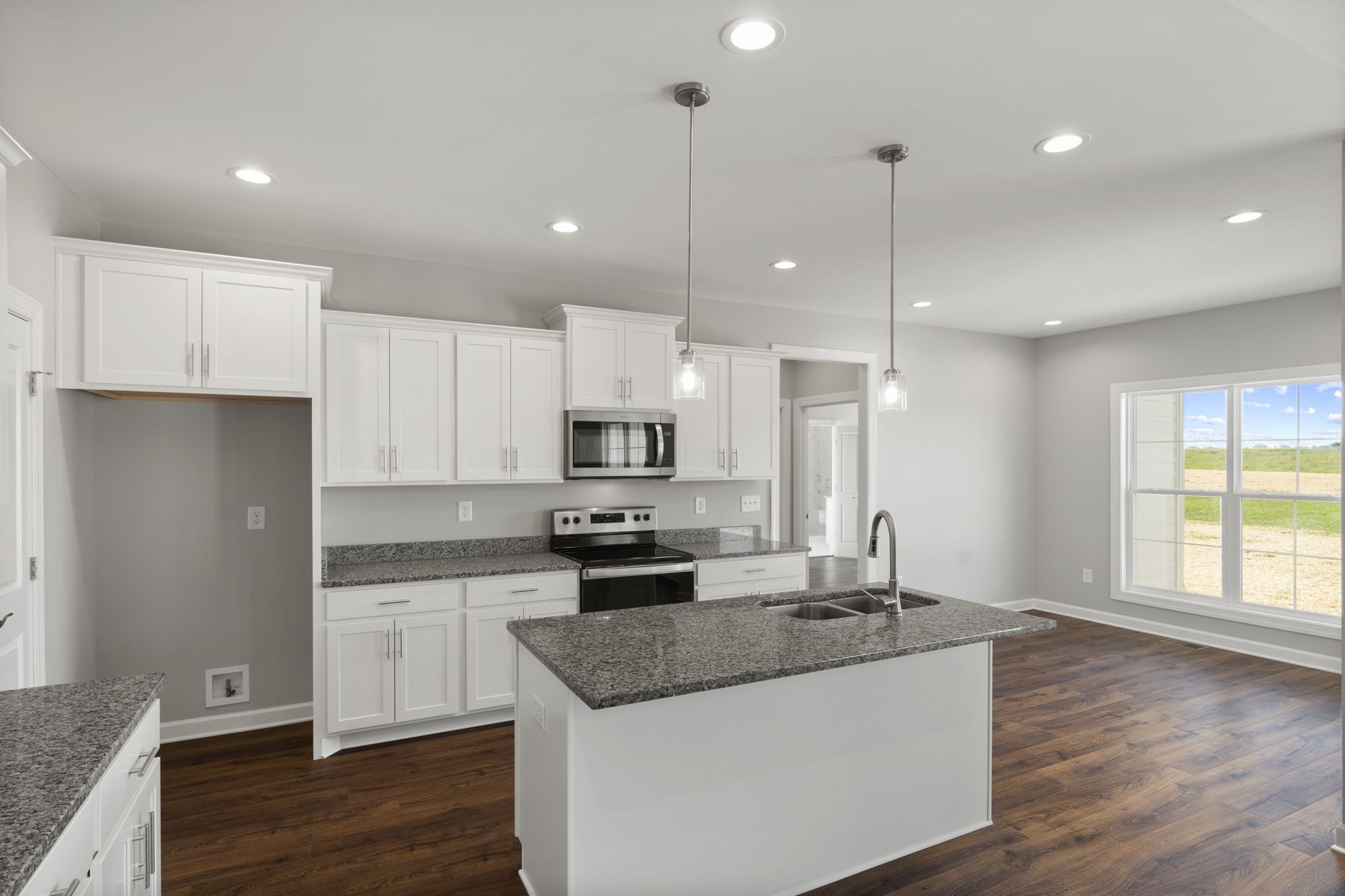 5557 Borthick Road Springfield, TN 37172 - Photo 16 of 48 a kitchen with stainless steel appliances granite countertop a sink a stove a refrigerator and white cabinets with wooden floor