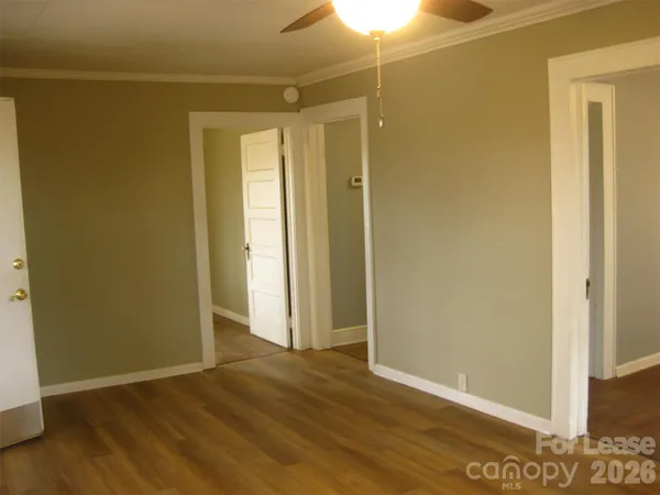 a view of an empty room with wooden floor