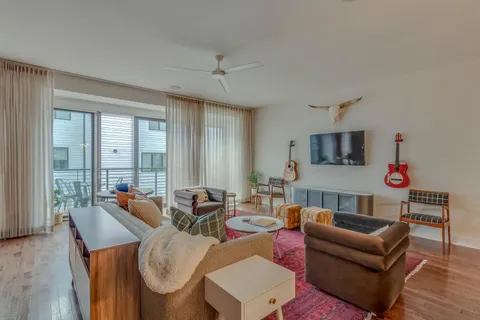 a living room with furniture kitchen view and a flat screen tv