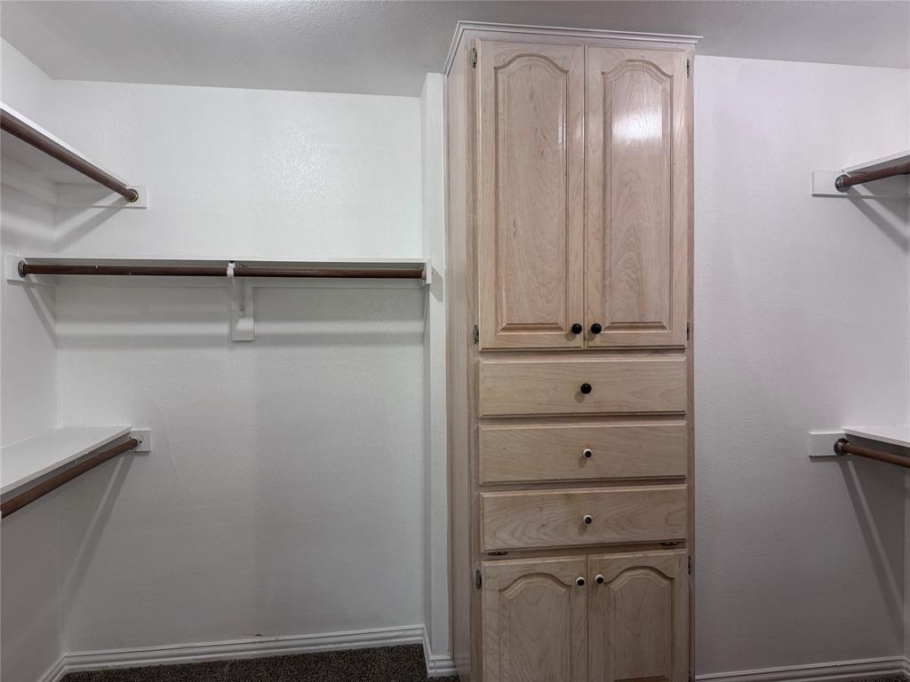 1704 South Bowen Road Pantego, TX 76013 - Photo 17 of 37 Built-in light wood-finish cabinetry featuring multiple drawers and upper and lower storage, complemented by wraparound shelving and hanging rods