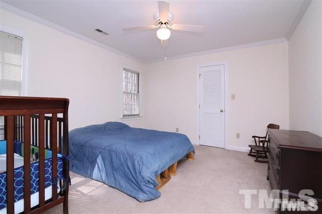805 Thatcher Way Raleigh, NC 27615 - Photo 14 of 25 a bedroom with a bed and a chandelier
