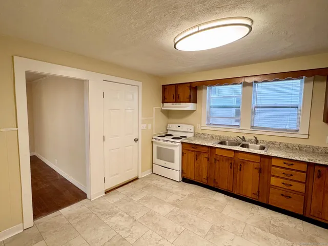 a large kitchen with stainless steel appliances granite countertop a stove and a sink