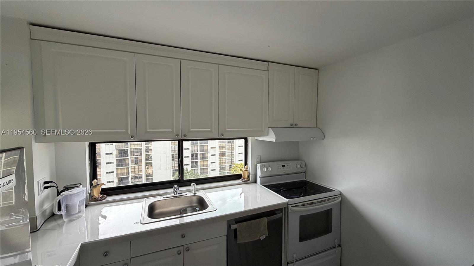 17011 North Bay Road, Unit 912 Sunny Isles Beach, FL 33160 - Photo 12 of 43 a kitchen that has a sink and a stove with wooden floor