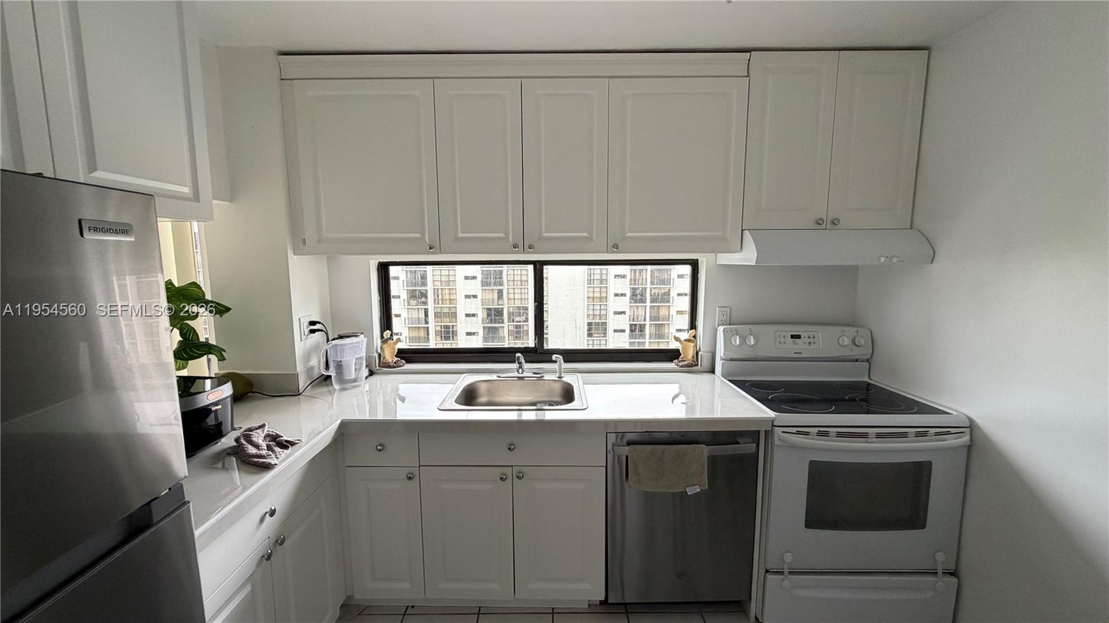 17011 North Bay Road, Unit 912 Sunny Isles Beach, FL 33160 - Photo 14 of 43 a kitchen with a stove a sink and a refrigerator