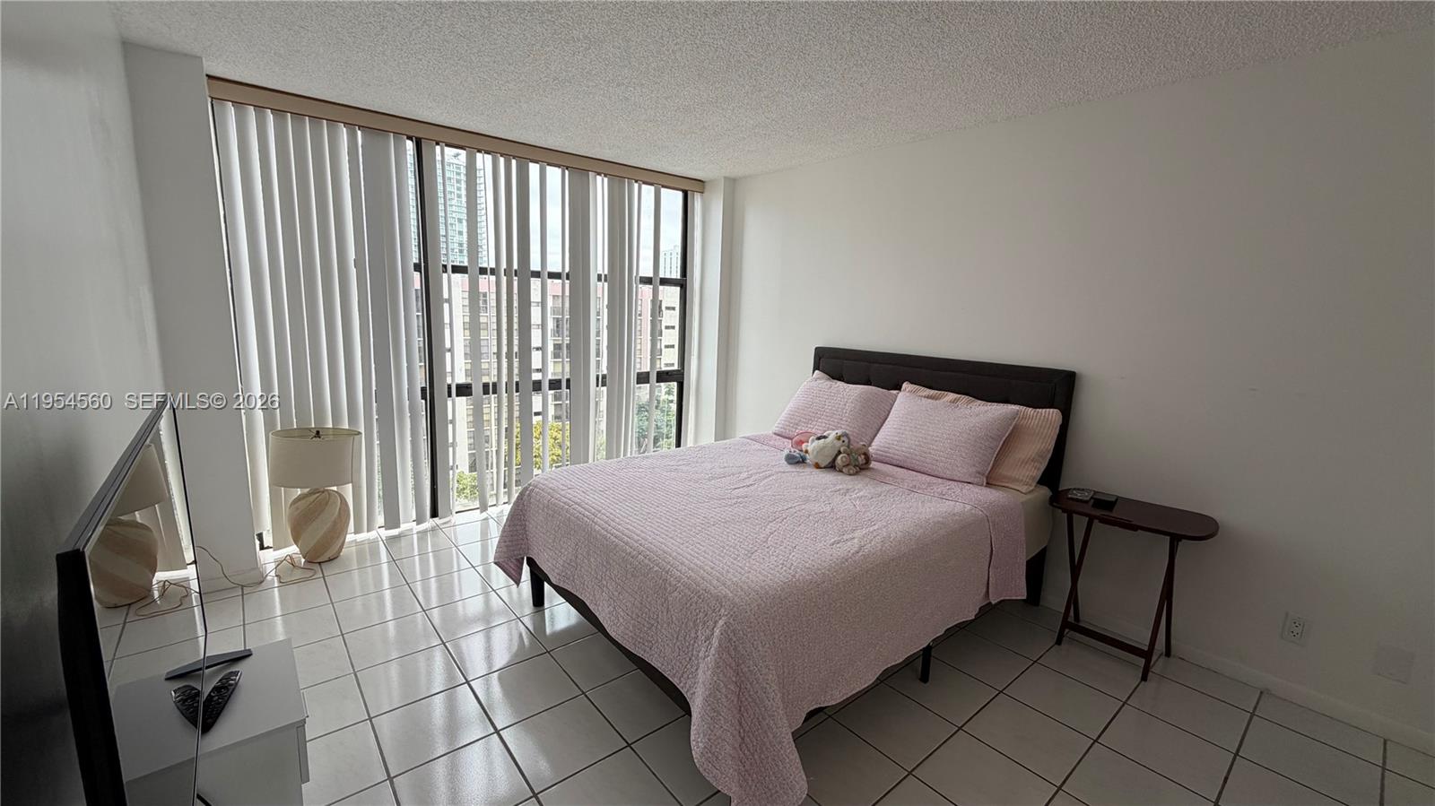 17011 North Bay Road, Unit 912 Sunny Isles Beach, FL 33160 - Photo 19 of 43 a bed sitting in a bedroom next to a window