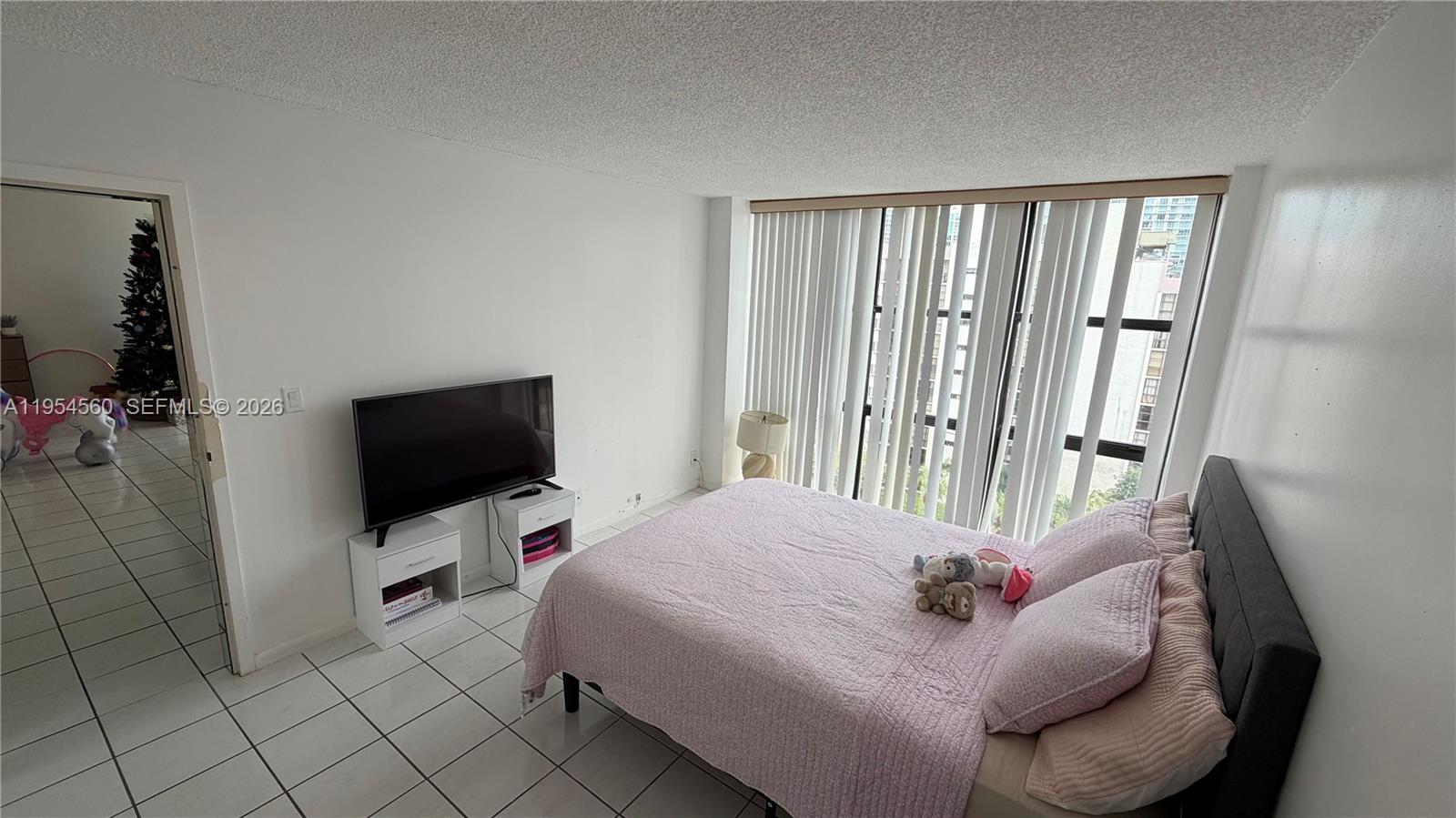 17011 North Bay Road, Unit 912 Sunny Isles Beach, FL 33160 - Photo 20 of 43 a bedroom with a bed tv and a window